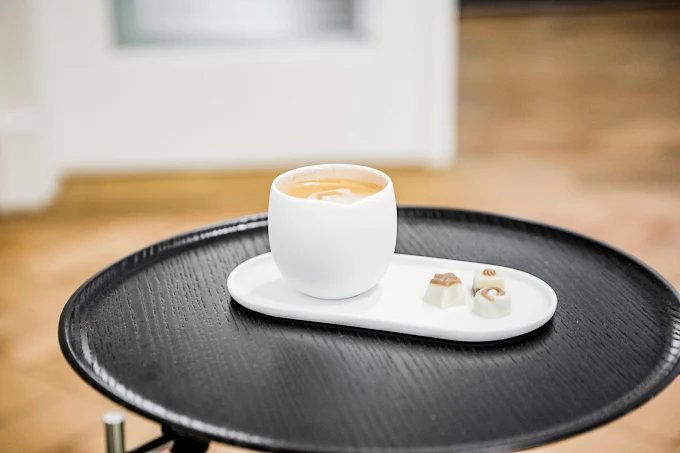 Espresso auf einem schwarzen Beistelltisch im Büro